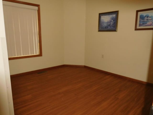 unfurnished room with dark hardwood / wood-style flooring