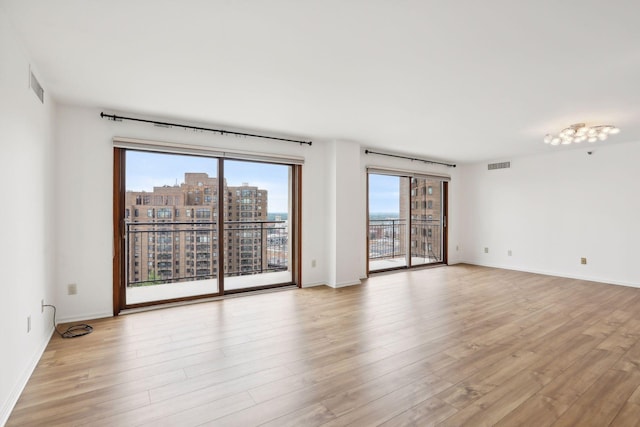 unfurnished room with plenty of natural light and light hardwood / wood-style flooring