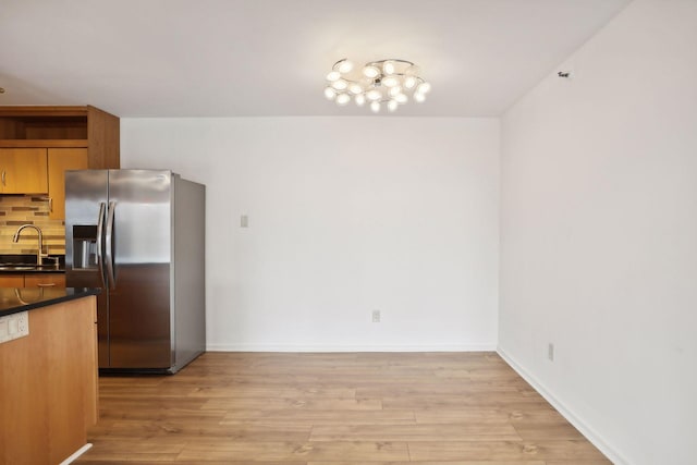 kitchen featuring light hardwood / wood-style flooring, sink, tasteful backsplash, and stainless steel refrigerator with ice dispenser