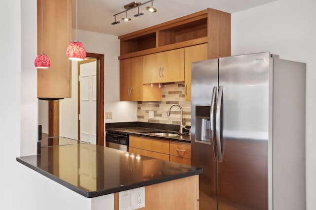 kitchen featuring kitchen peninsula, sink, decorative backsplash, hanging light fixtures, and appliances with stainless steel finishes