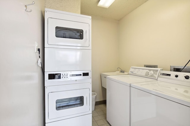 laundry room featuring sink, a textured ceiling, washing machine and dryer, and stacked washer / dryer