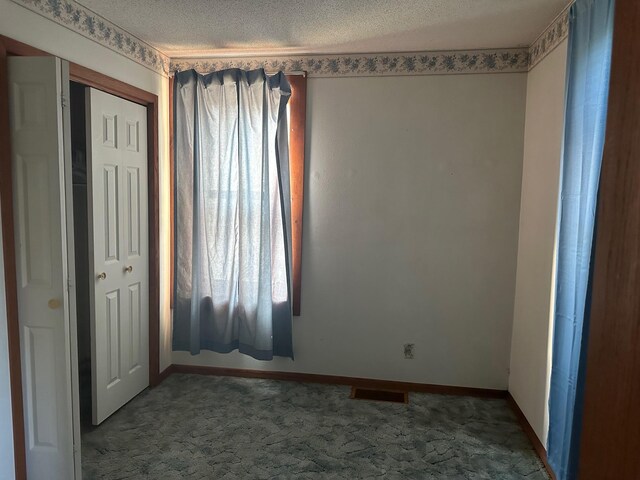 unfurnished bedroom with a closet, a textured ceiling, and carpet flooring