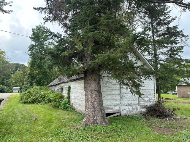 view of property exterior with a storage unit and a yard