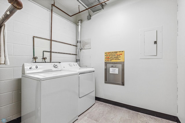 laundry room featuring laundry area, baseboards, washer and dryer, electric panel, and concrete block wall