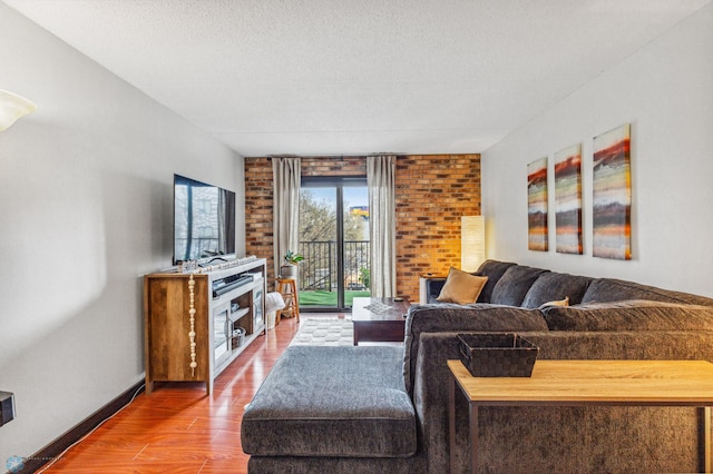 living area with a textured ceiling, wood finished floors, and baseboards