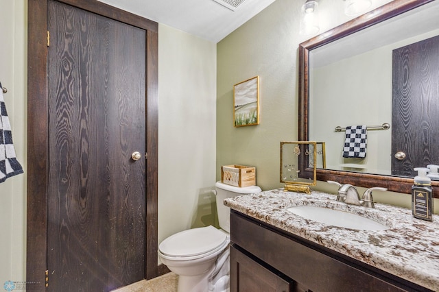 half bathroom featuring vanity and toilet