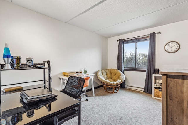 carpeted office space with a baseboard heating unit and a textured ceiling