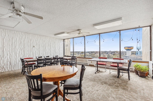 dining room with ceiling fan, carpet floors, a textured ceiling, and a baseboard heating unit