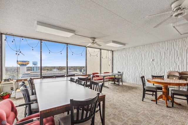 carpeted dining area featuring a textured ceiling, a ceiling fan, and floor to ceiling windows