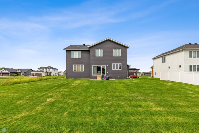 rear view of property with a lawn and a patio