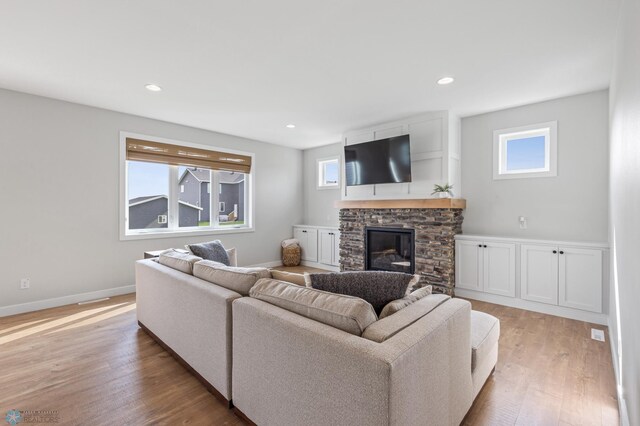 living room with a fireplace and light wood-type flooring