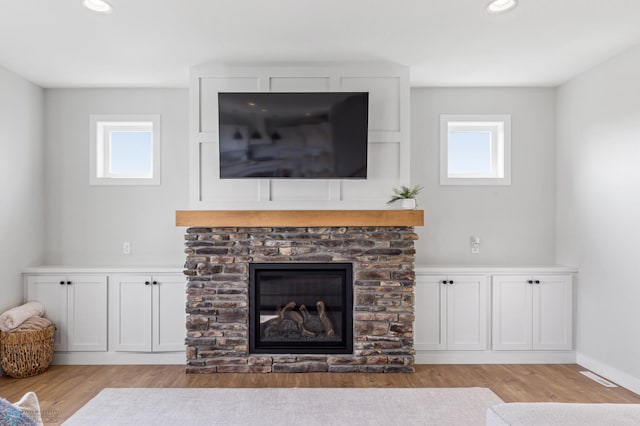 living room with a fireplace, plenty of natural light, and light hardwood / wood-style floors