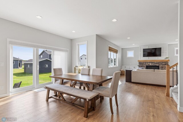 dining space with light hardwood / wood-style floors and a fireplace