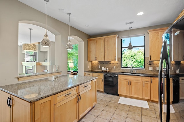 kitchen featuring dark stone counters, dishwasher, sink, decorative backsplash, and light brown cabinets