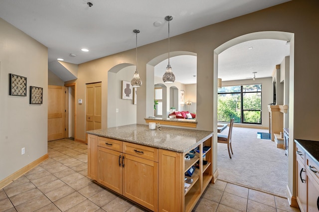 kitchen with light stone counters, light tile patterned floors, and hanging light fixtures