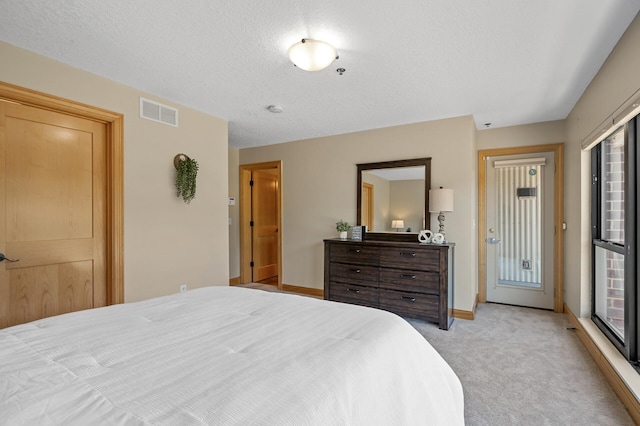 carpeted bedroom with a textured ceiling and multiple windows