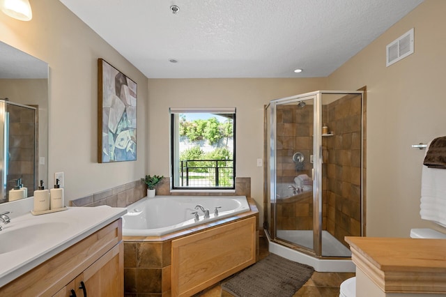 full bathroom featuring vanity, a textured ceiling, tile patterned flooring, and shower with separate bathtub