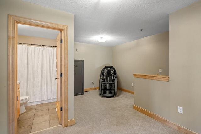 workout room with a textured ceiling and light carpet