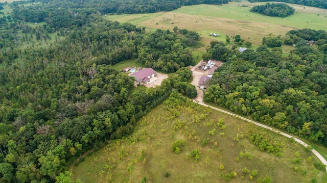 drone / aerial view featuring a view of trees and a rural view