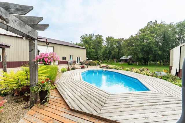 outdoor pool with a lawn and a wooden deck