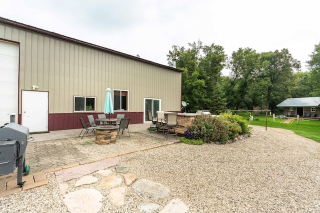 back of property with a patio area and an outdoor fire pit