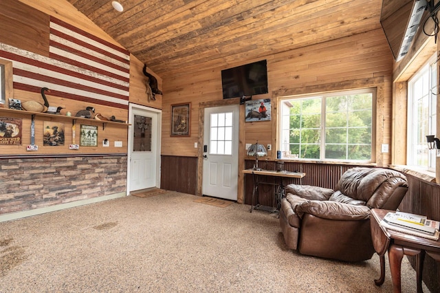 carpeted living room with wood walls, wooden ceiling, and high vaulted ceiling