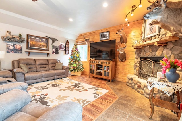 living area with wooden walls, recessed lighting, and a fireplace