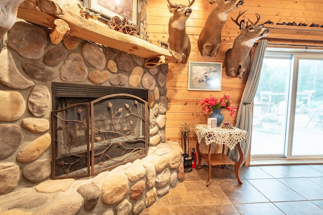 interior details featuring a stone fireplace and wooden walls