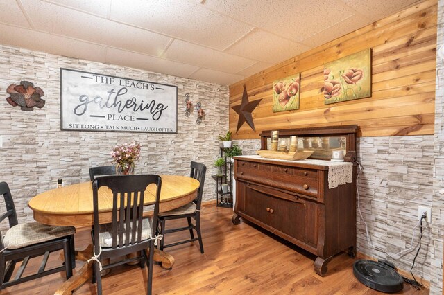 dining area featuring a drop ceiling and light wood finished floors