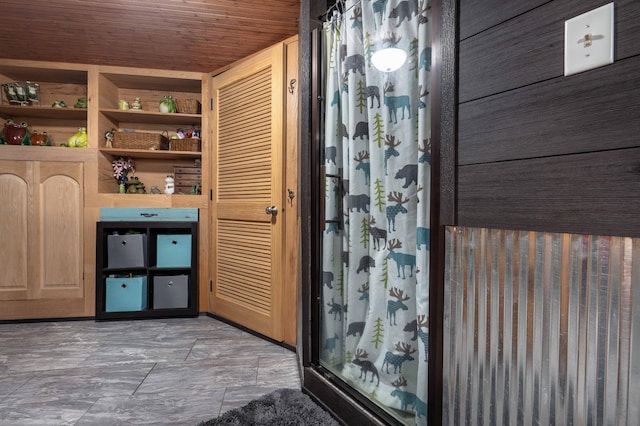 bathroom with a shower stall and wood ceiling