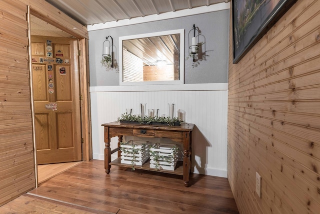 hallway featuring a wainscoted wall and wood finished floors