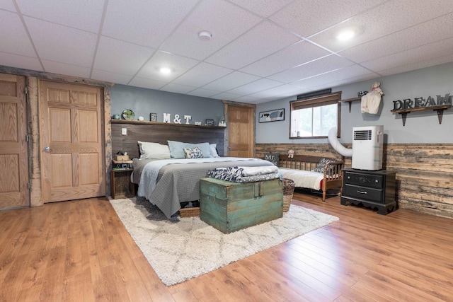 bedroom with wood finished floors and a paneled ceiling