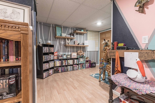 interior space with a paneled ceiling and wood finished floors