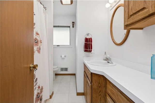 bathroom with tile patterned flooring, vanity, and toilet