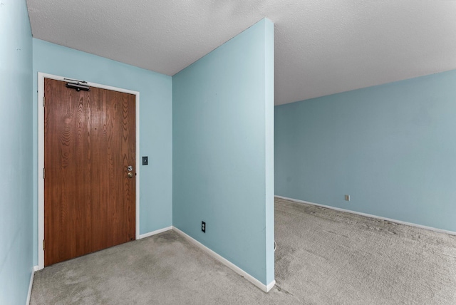 carpeted entrance foyer featuring a textured ceiling