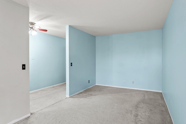 spare room with ceiling fan, a textured ceiling, and carpet flooring