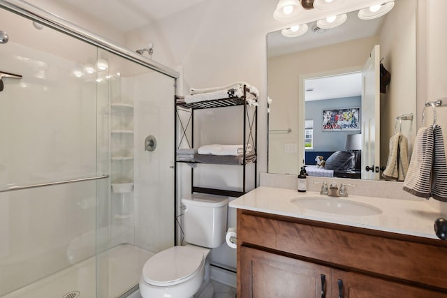 bathroom featuring toilet, an enclosed shower, and vanity