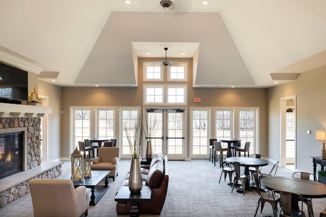 living room featuring a high ceiling, french doors, and a fireplace