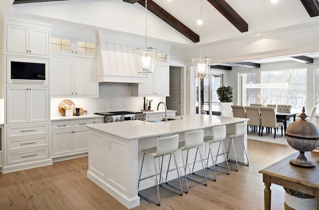 kitchen featuring sink, light hardwood / wood-style flooring, a kitchen bar, and tasteful backsplash