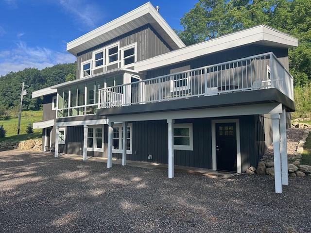 rear view of house featuring a wooden deck