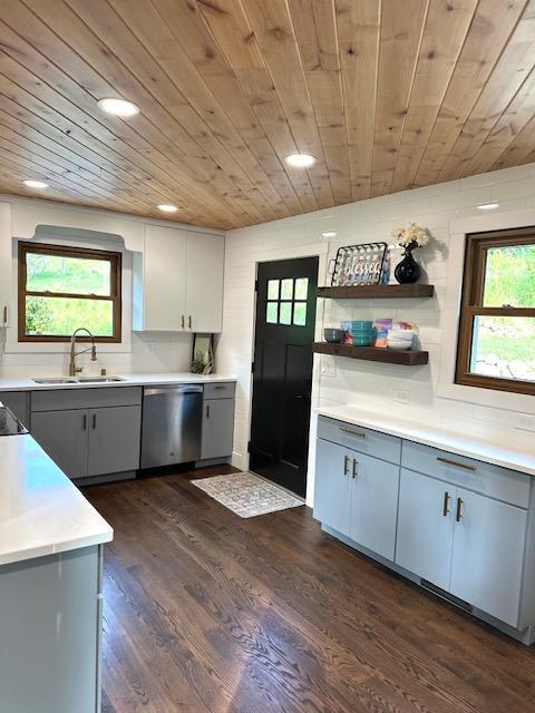 kitchen featuring a sink, gray cabinets, light countertops, and dishwasher