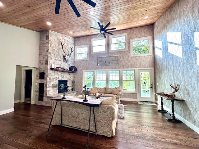 living area with wooden ceiling, dark wood finished floors, and a towering ceiling