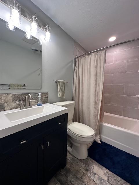 bathroom featuring vanity, toilet, and shower / bathtub combination with curtain