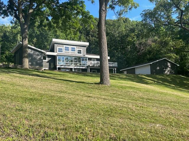 rear view of property featuring a deck and a yard