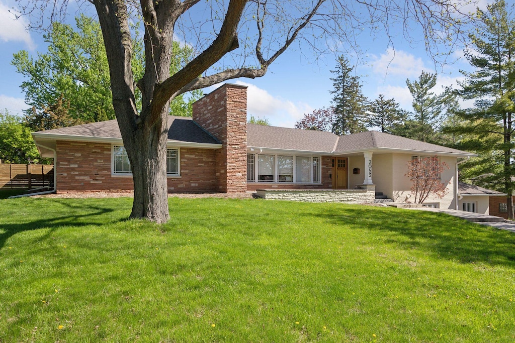 rear view of house with a chimney and brick siding