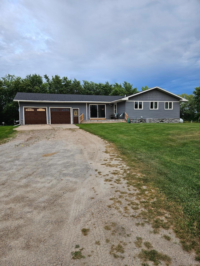 ranch-style home with a front yard, an attached garage, and dirt driveway