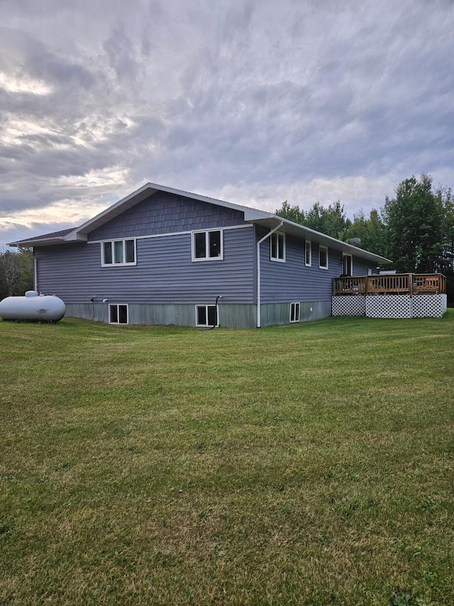 rear view of property with a yard and a wooden deck