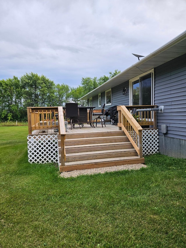 wooden deck featuring a lawn