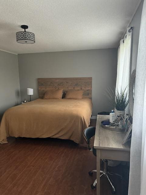 bedroom featuring dark wood-style floors and a textured ceiling