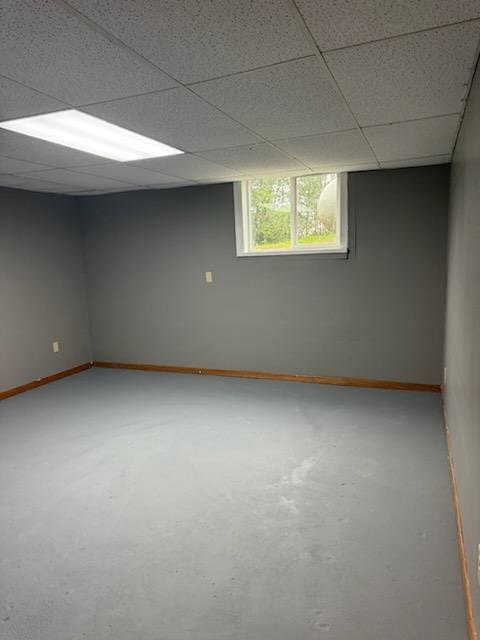 unfurnished room featuring a paneled ceiling and baseboards